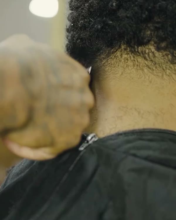 Barbeiro finalizando um corte
